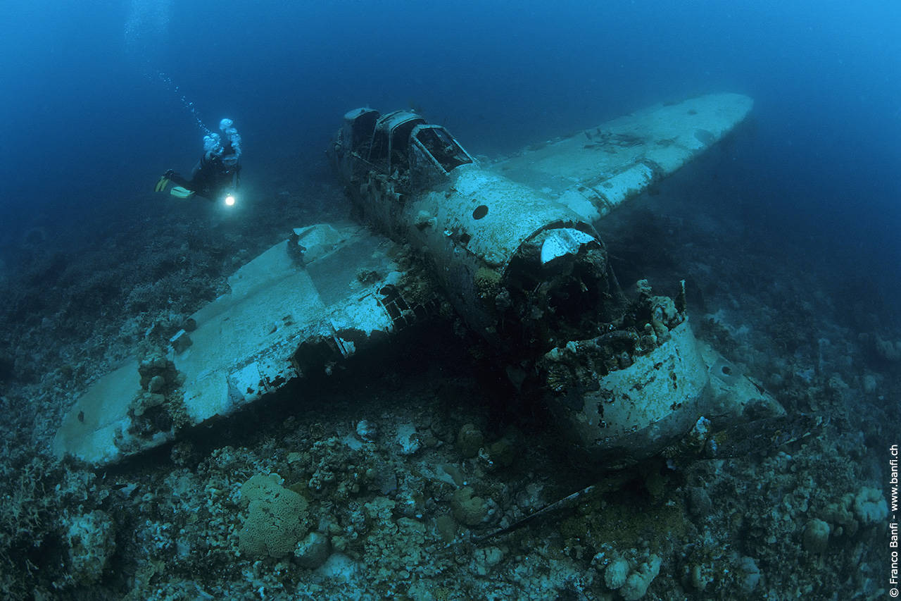 Diver hovering around an airplane wreck of a sub zero in Palau