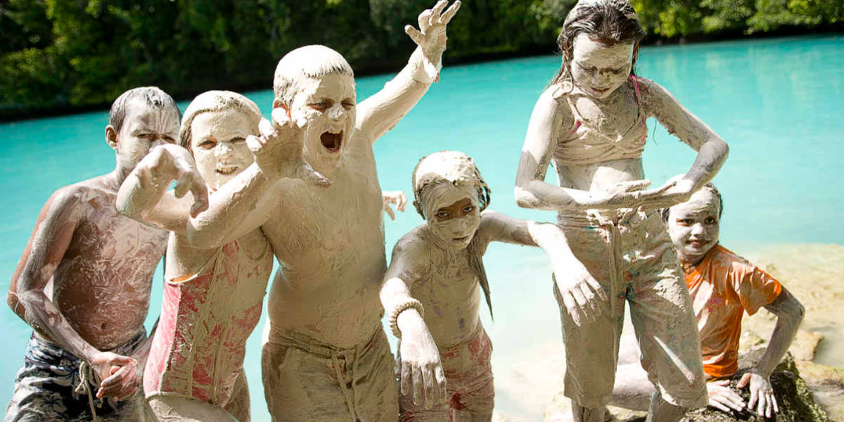 6 kids full of white mud playing at Milky Way Palau