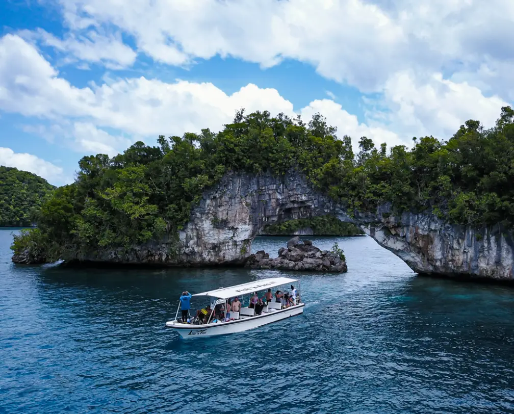 Fish 'n Fins boat in from of the arch in Palau, the arch is a natural wonder