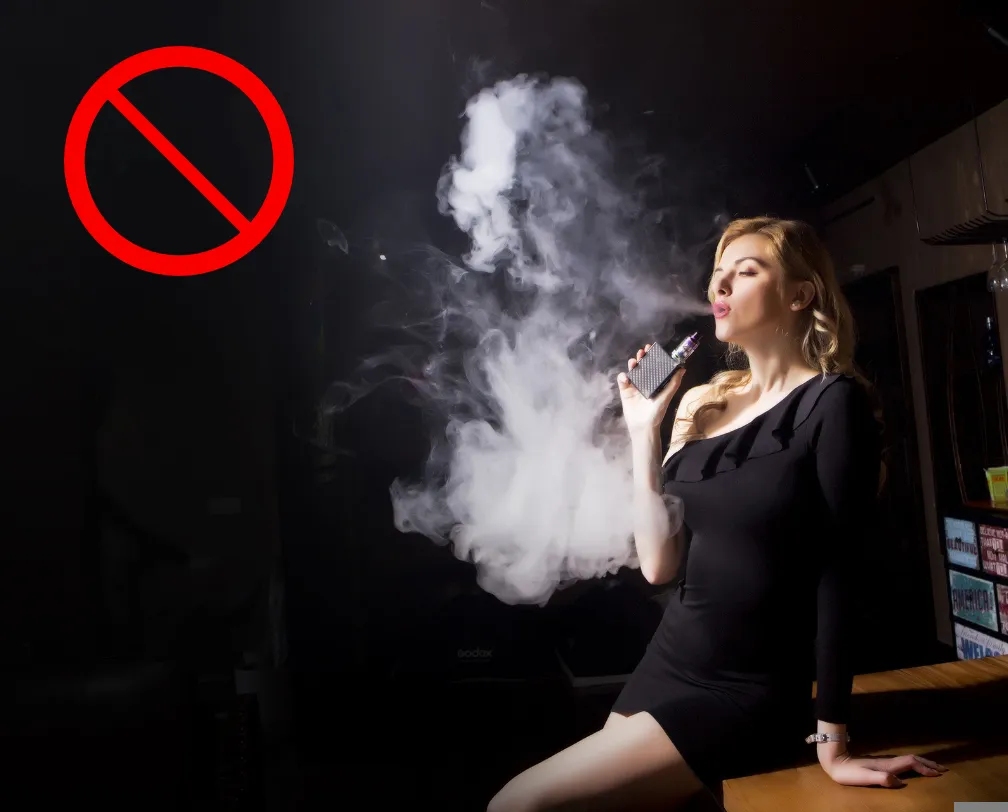 woman smoking an e-cigarette blowing lots of smoke