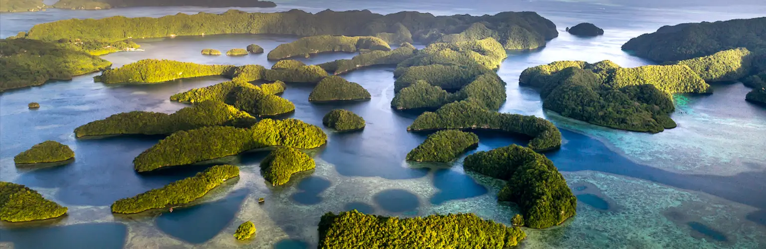 aerial photo of the Rock Islands in Palau, with ocean and Rock islands in a golden light